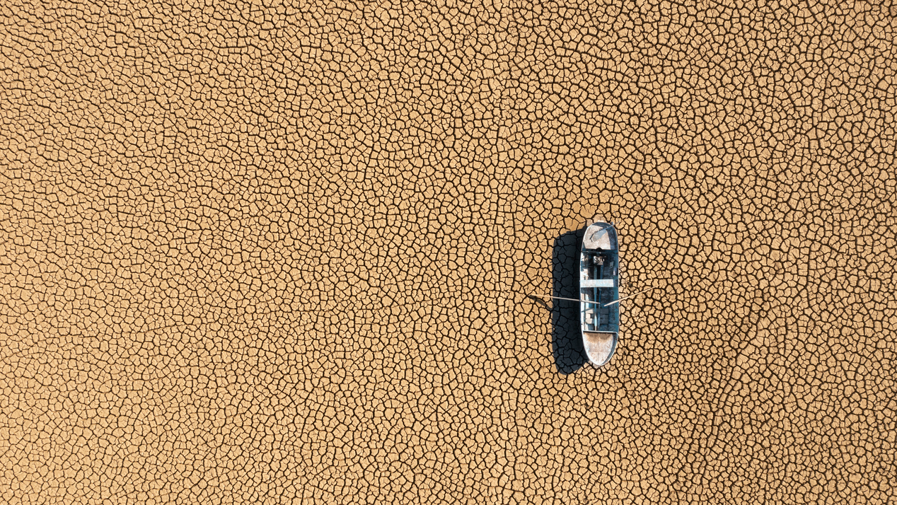 Aerial view of a fishing boat on the dried-up surface of a lake in Burdur, Turkey, Photo: temizyurek, IStock