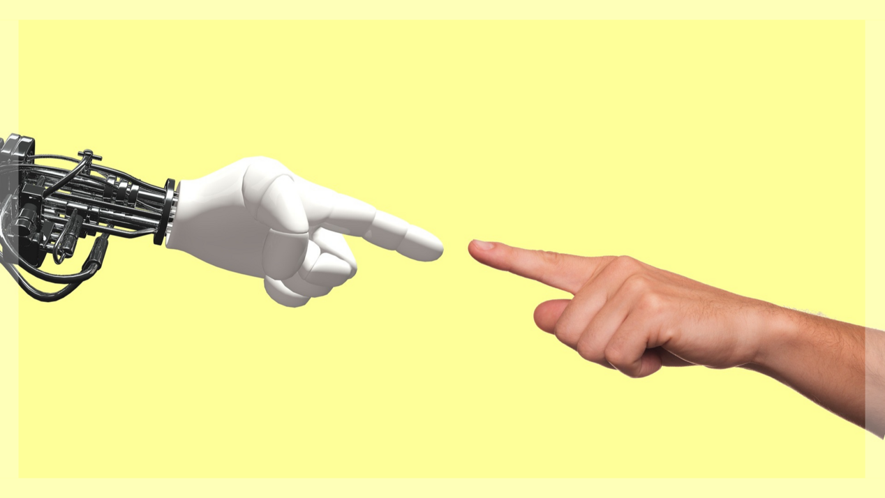 Robot hand and human hand almost touch each other with an outstretched index finger.
