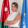 Magda Janiszewska posing in front of Polish flag and United Nations flag.